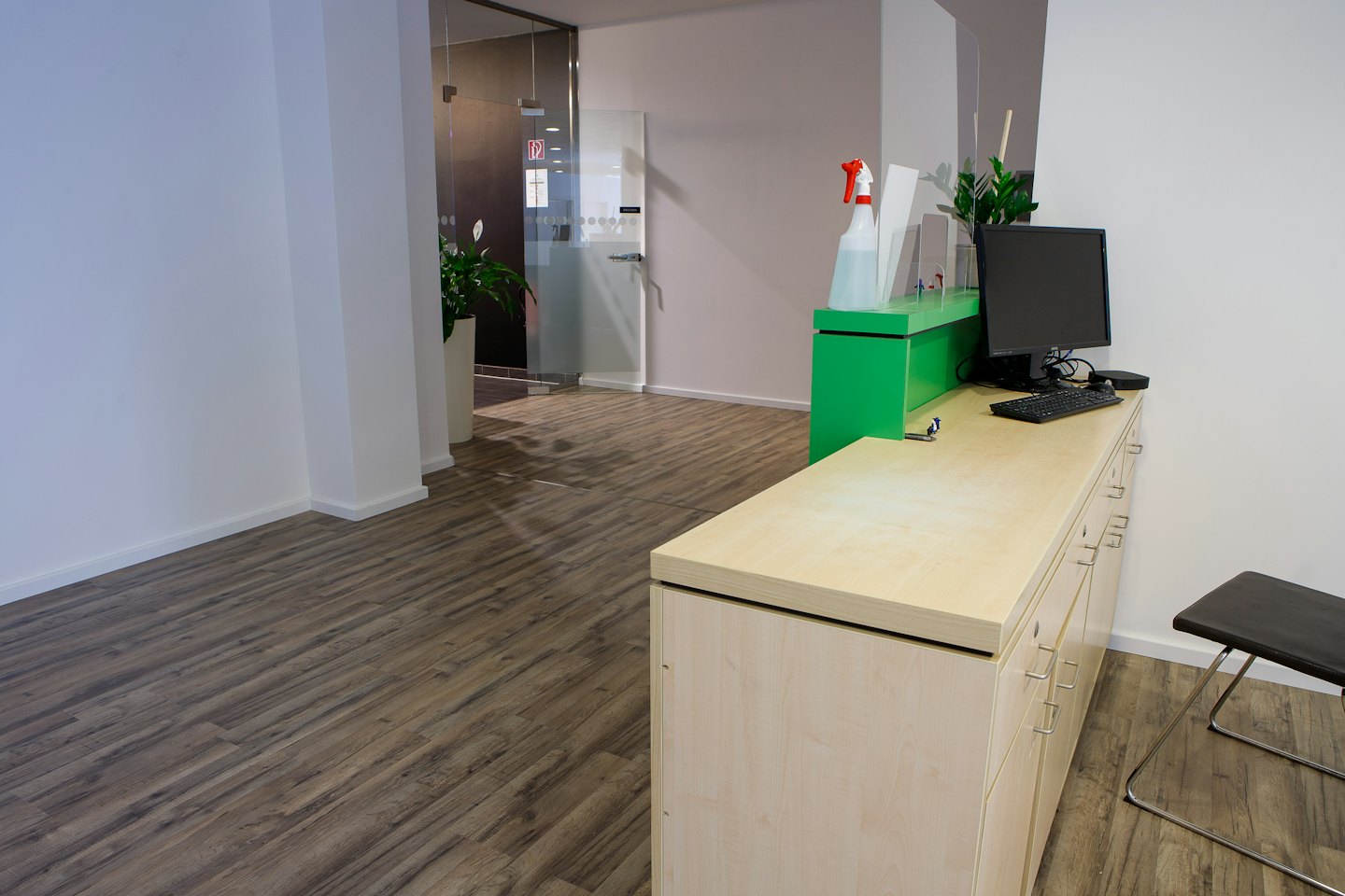 Moderne Bürorezeption mit Holztresen und Pflanzen.